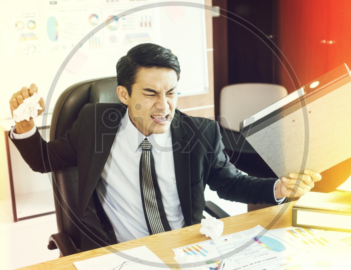 Concept of stress and frustration of a businessman throwing a crumpled paper