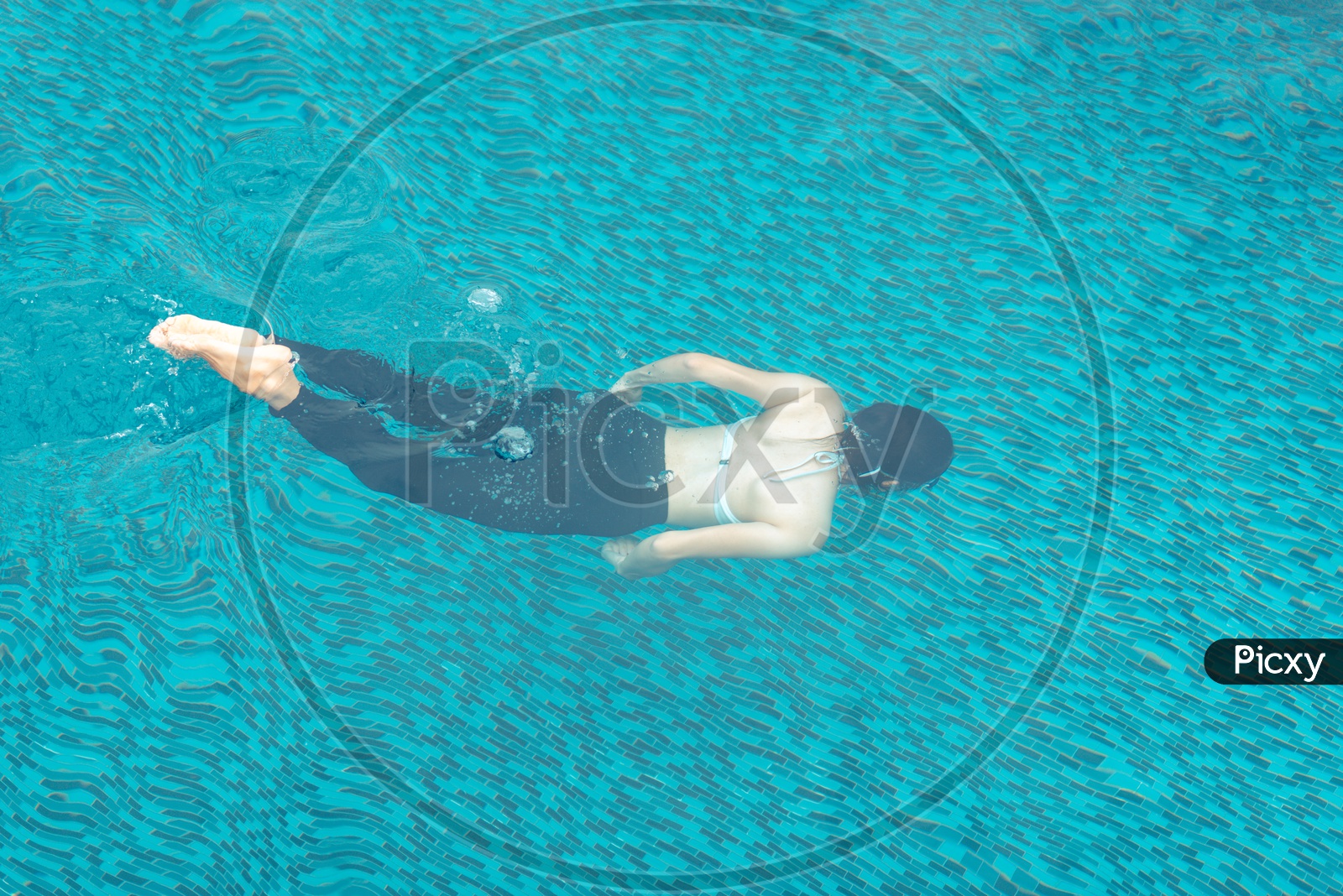 Teenage Asian girl swimming in the pool