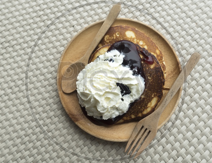 Breakfast With Pancakes Served  With Whip cream And Blueberry Jam On an Restaurant table Background