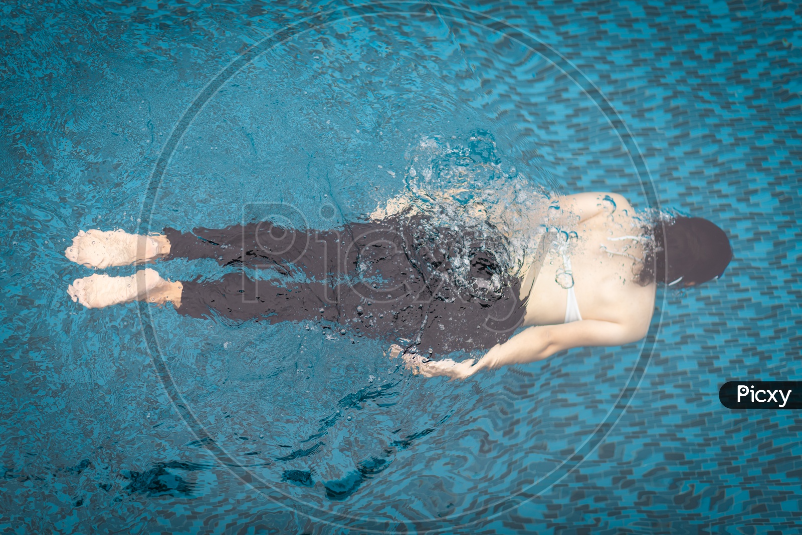 An Asian woman relaxing in swimming pool