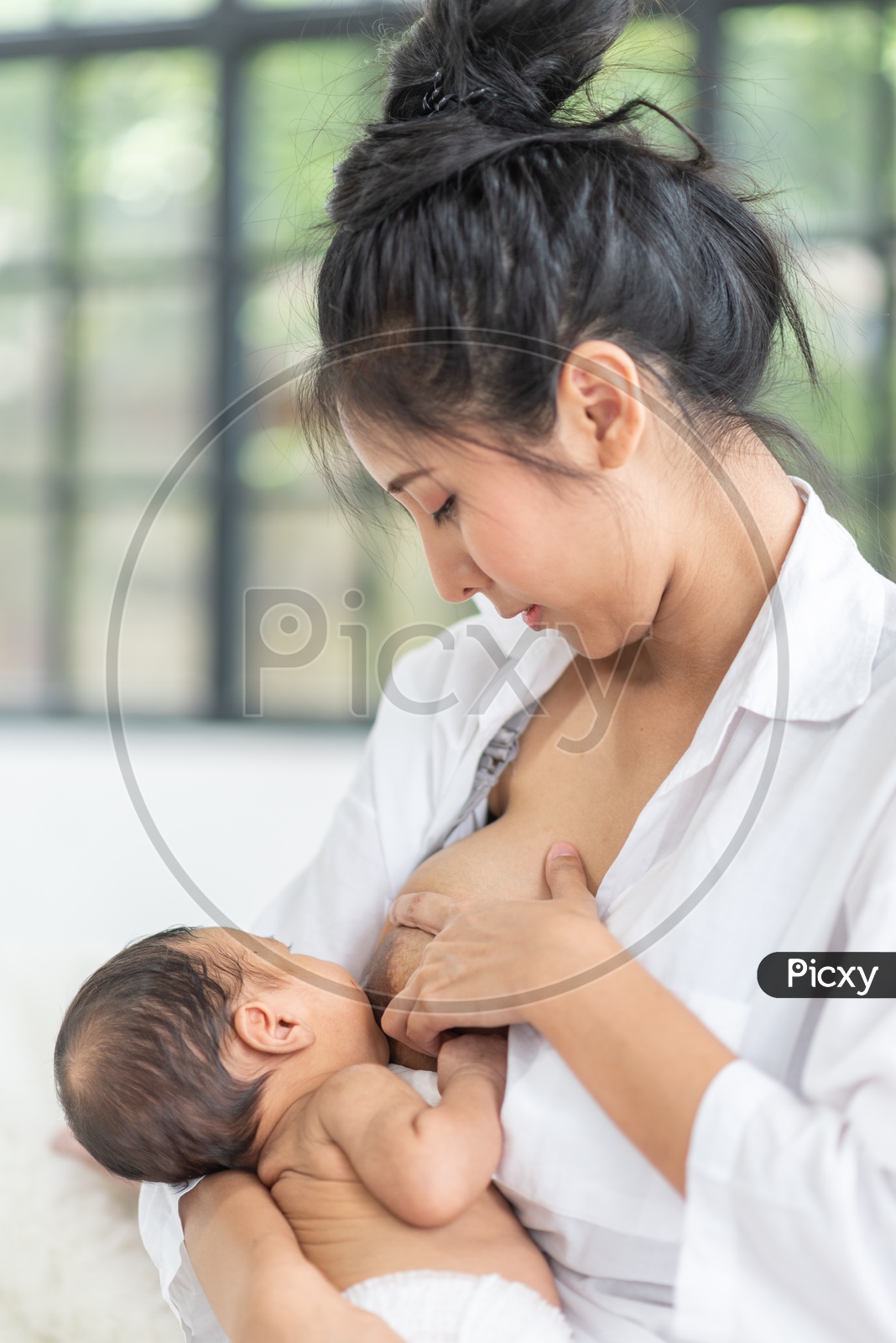 Asian Mother breastfeeding milk to her baby boy