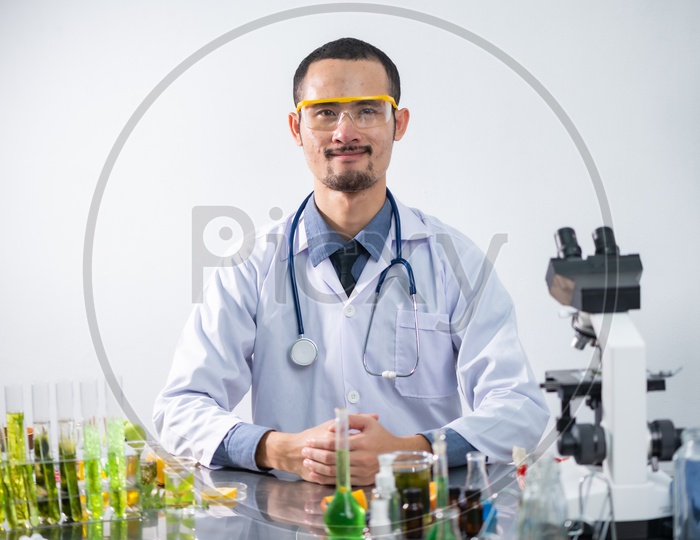 Young Male Asian Research Scientist with Protective Eyeglasses and Stethoscope in Laboratory