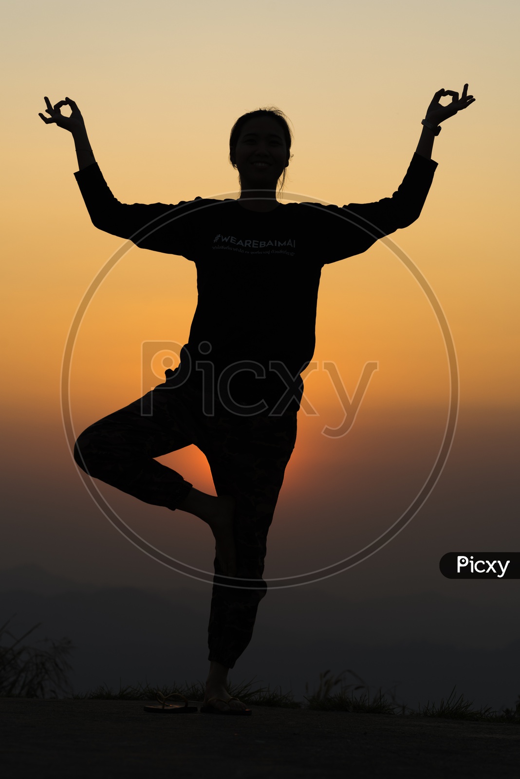Silhouette  Of People Practicing  Yoga Over Sunset Sky In Background