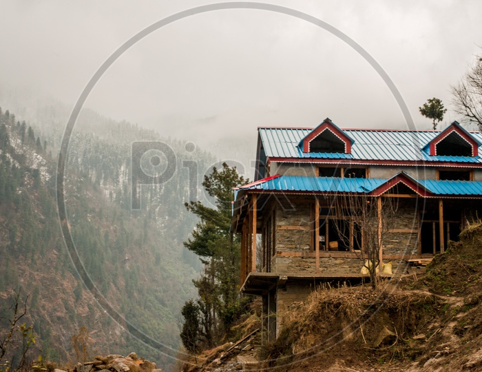 Typical wooden alpine house with Mountains in Background at the Himalayas