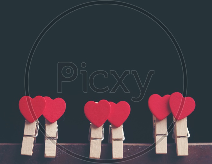Love Concept For Valentines Day With red Hearts Couples  Hung On an isolated Black background