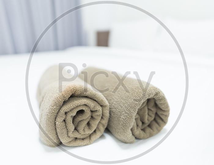 Towels Rolled and Kept On bed In a Bedroom