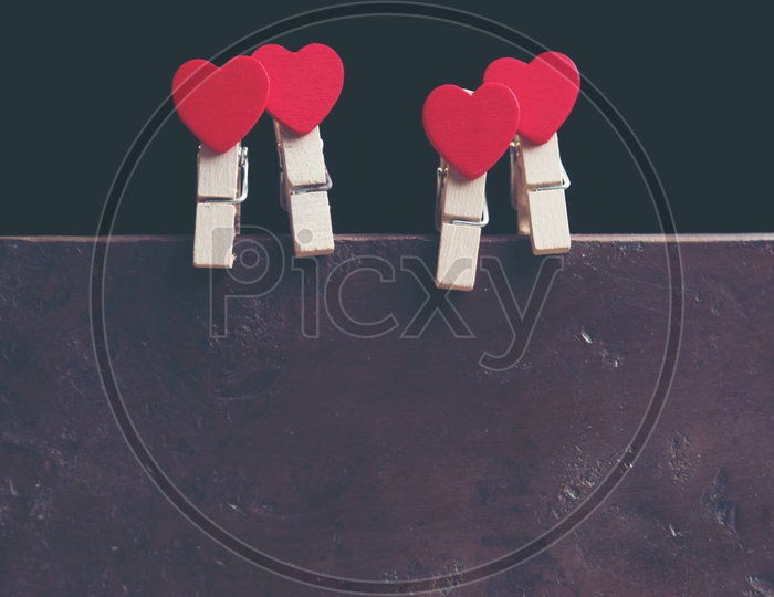 Red Hearts Couple Hung Together For Valentines Day Concept  With Vintage Filter On an Isolated Black Background