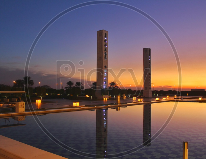 Reflection of a tall buildings in a swimming pool during sunset