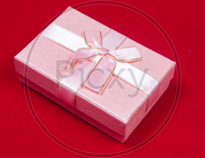 A pink gift box on a red background - Art picture background of Love