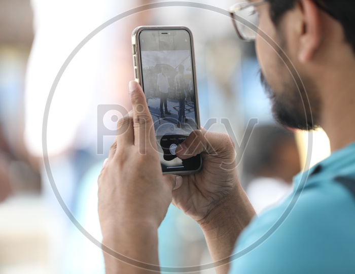 A Man taking a picture with an iPhone