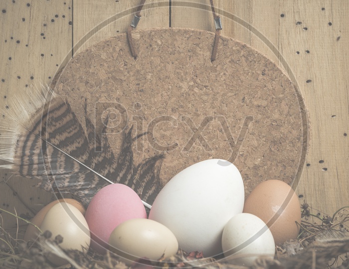 Easter Festival Template Background With Colour Eggs In a Basket Over Wooden Background