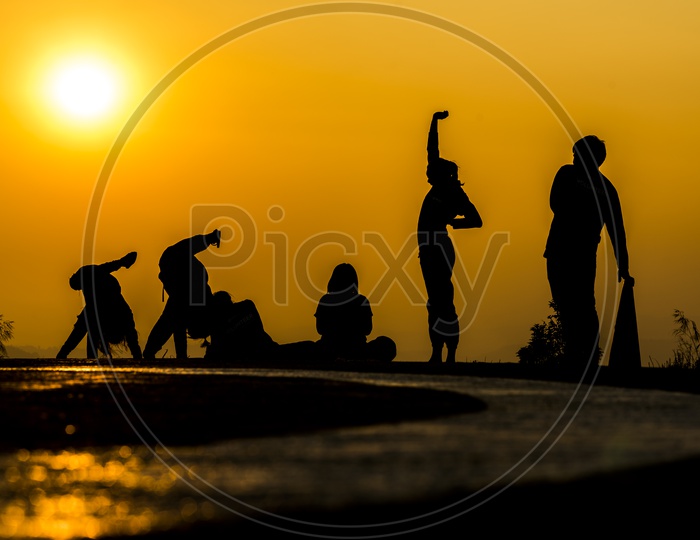 silhouette of  group  of People  practicing yoga on the beach at sunset