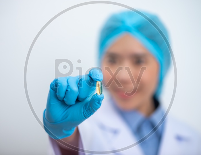 Young Asian Woman Holding Fish oil Pill or Capsule in Hand, Healthy Nutrition