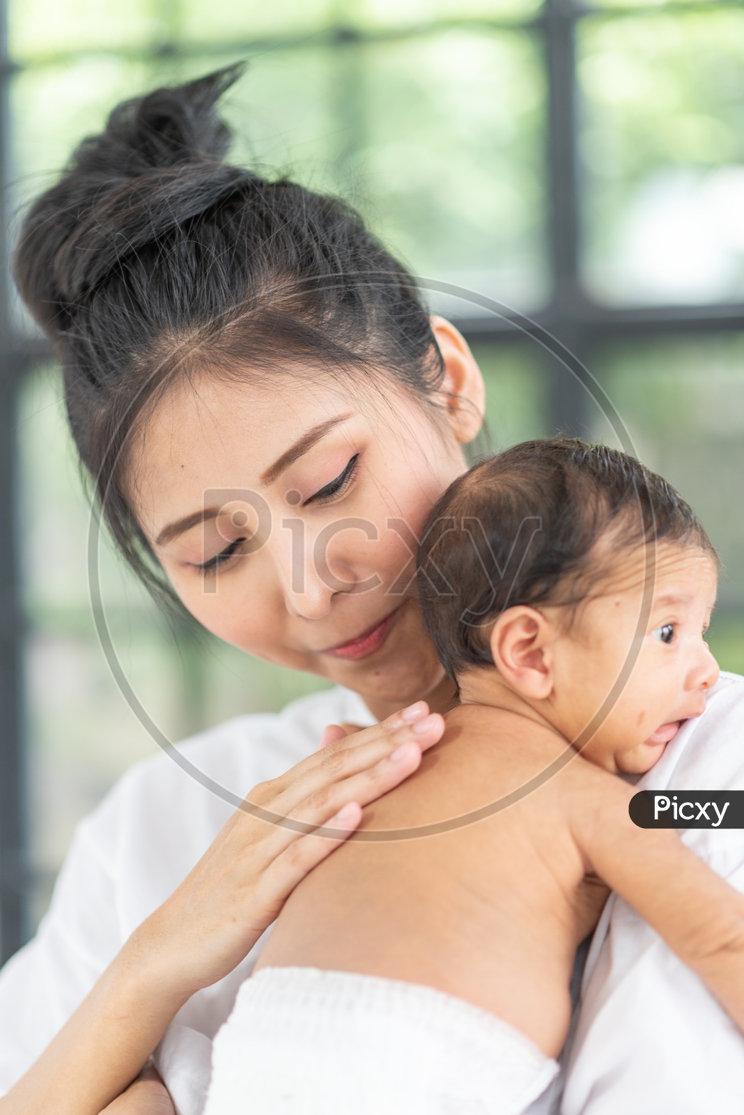 Asian Mother putting her baby to sleep in her arms