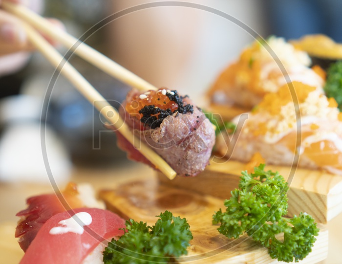 Sushi Dish With Raw Fish Served  In a Restaurant Eating With Chopsticks