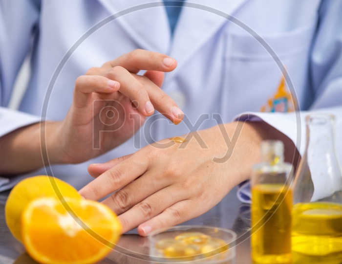 Asian Research Scientist Testing a Sample on Hand for Skin Care Product