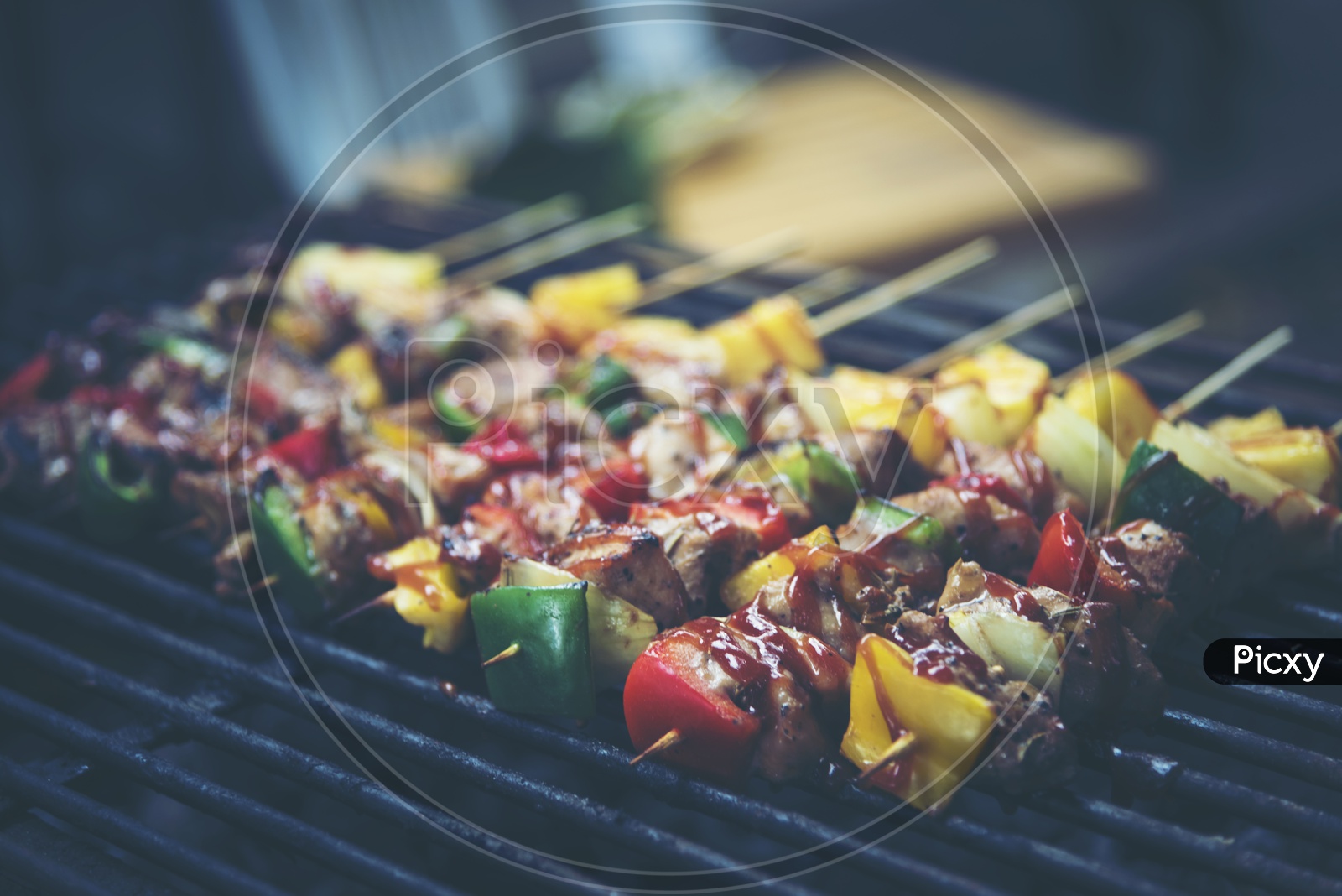 Grilled beef and vegetable BBQ skewers on the black background, side view, vintage filter image