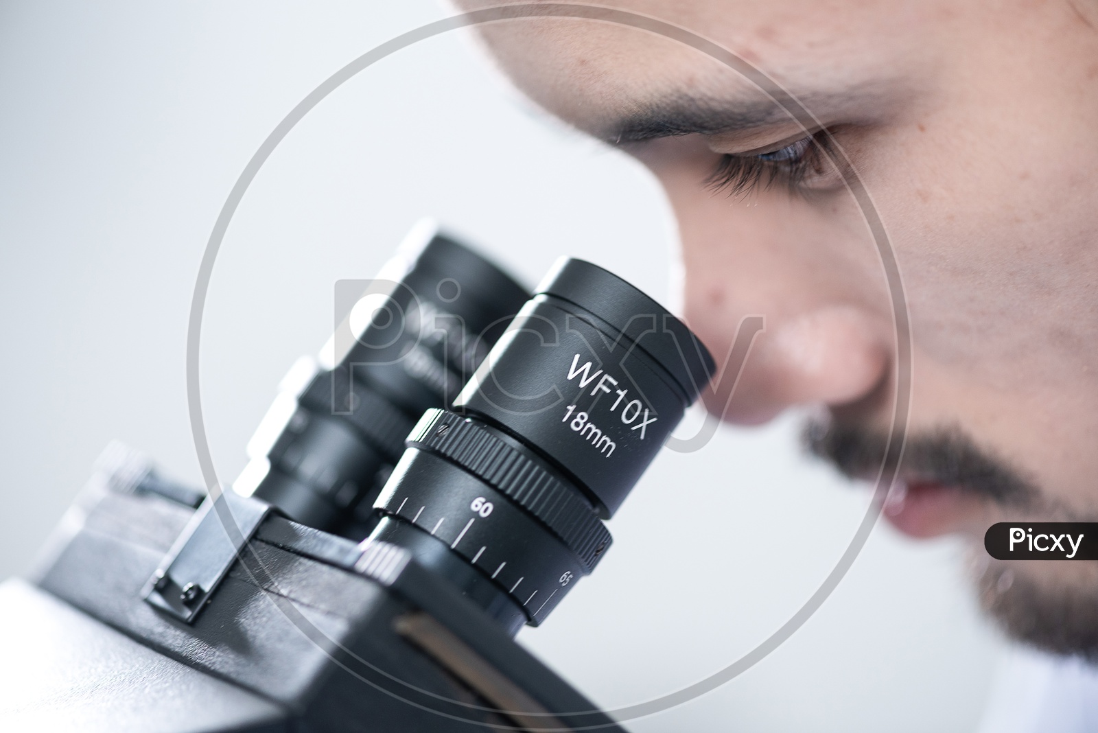 Closeup Shot of a Man Looking through Microscope