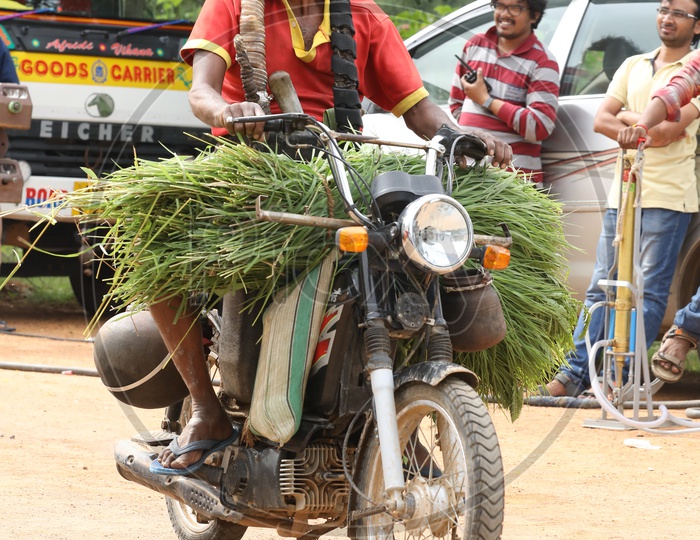 Palm Tree Climber carrying grass and toddy on  a motorcycle