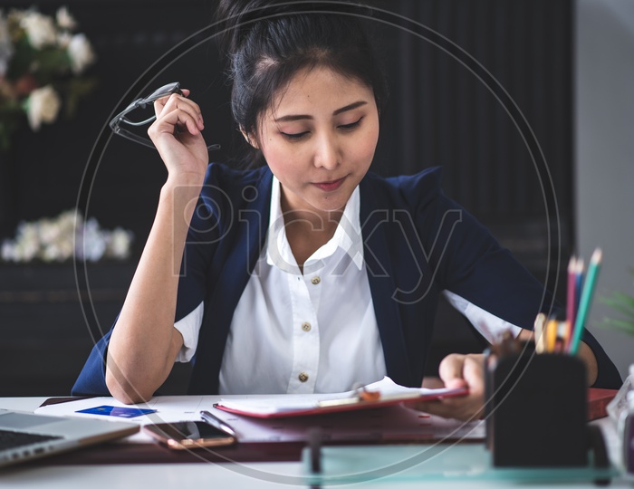 Young Asian Businesswoman verifying Documents at workplace