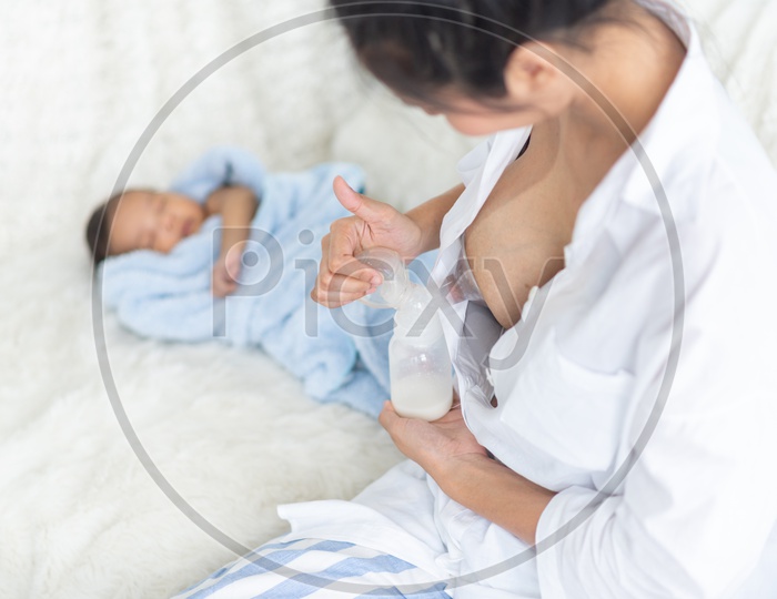 Young Mother pumping breastmilk to the baby bottle