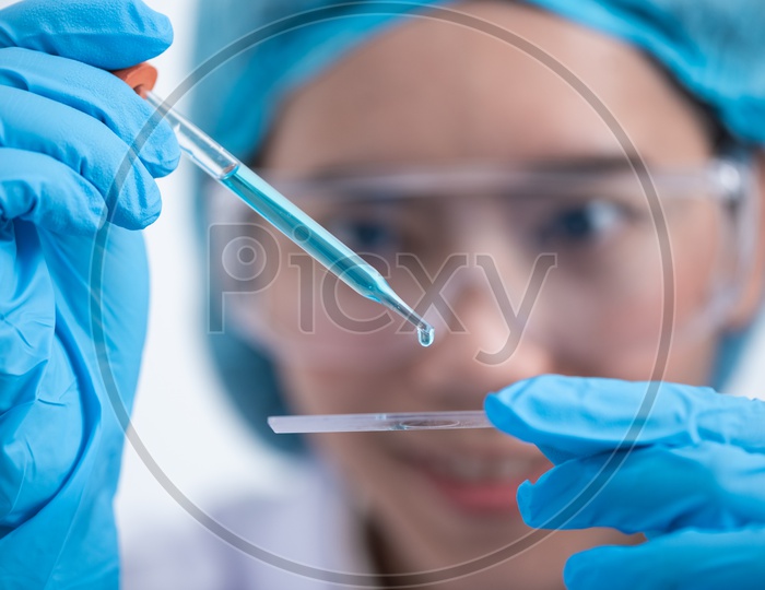 Young Asian Woman Medical Student or Scientist Analyzing a Sample