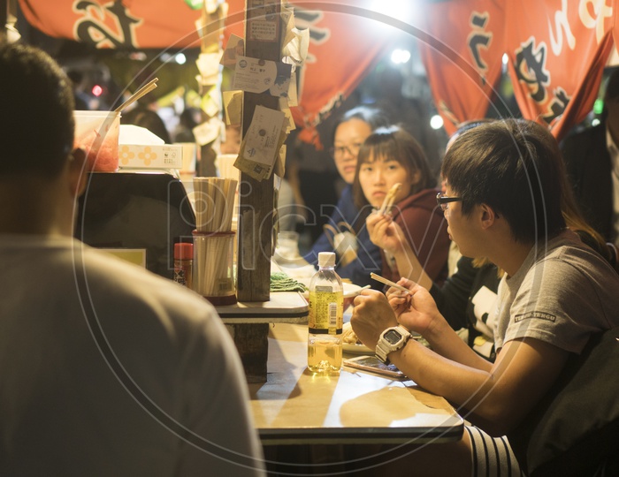 Japanese People eating  at Yatai mobile food stall during night in Fukuoka, Kyushu, Japan