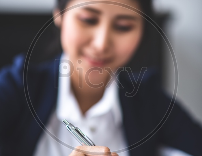 Portrait of Young Asian Businesswoman Filling Documents, Tax Papers