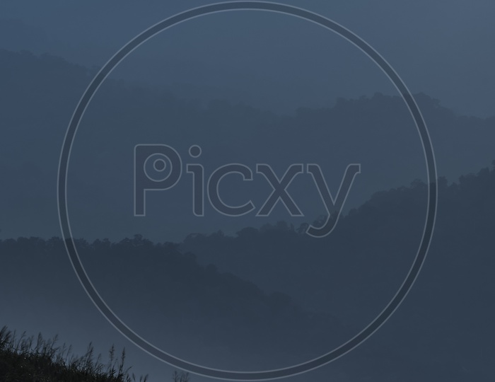 Landscape view of mountains in the fog during evening