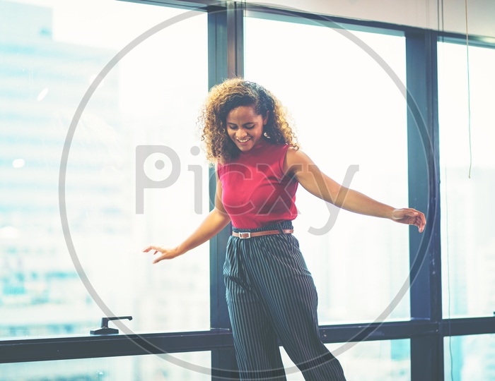 Portrait of smiling pretty young businesswoman playing and relaxing in Office