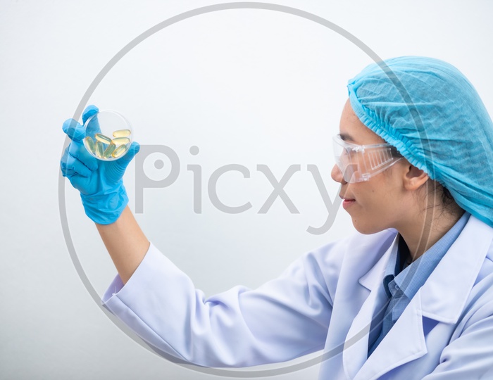 Young Asian Woman Scientist Holding Fish oil Pill or Capsule in Hand, Healthy Nutrition