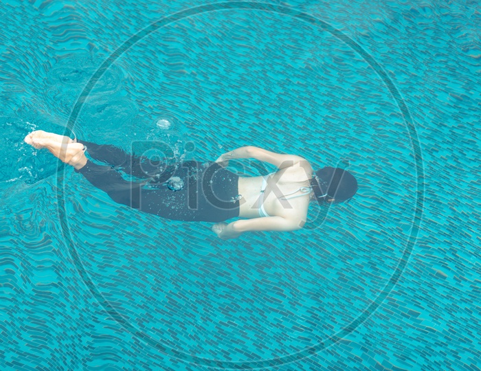 Teenage Asian girl swimming in the pool