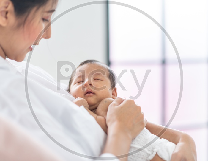 Portrait of baby boy sleeping in the arms of mother