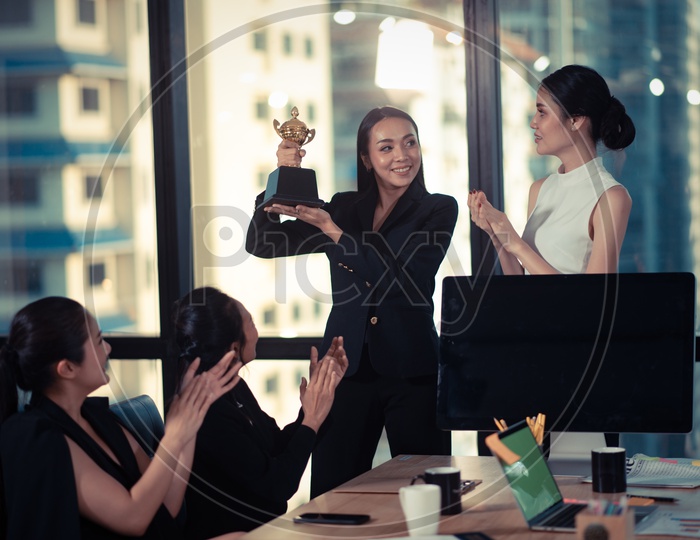 Young Asian Woman Holding Trophy in Hand, Successful or Achievement Concept