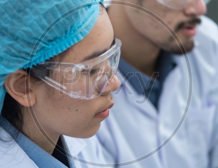 Asian Female Scientist with Protective Glass wear in Laboratory