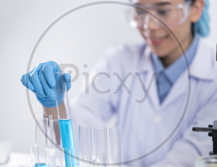 Young Asian Female Scientist Researching Chemical Solutions in Test Tube at Laboratory