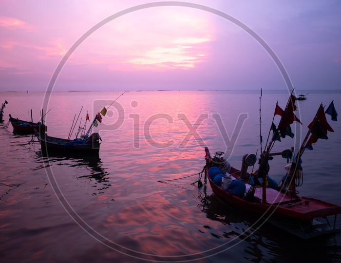 Local fishing boats during sunset hues in Thailand