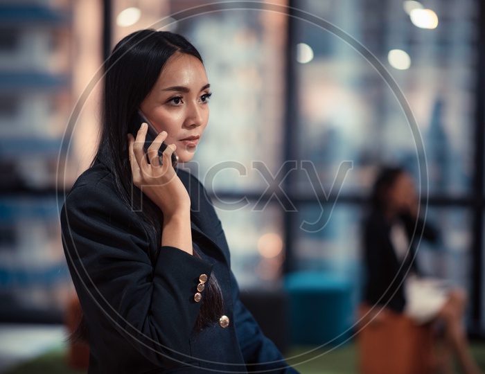 Young Asian Woman using Smartphone or Mobile in Office