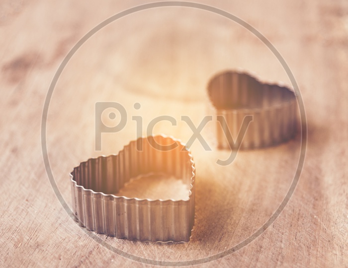 Heart shaped rings on wooden background with lens flare