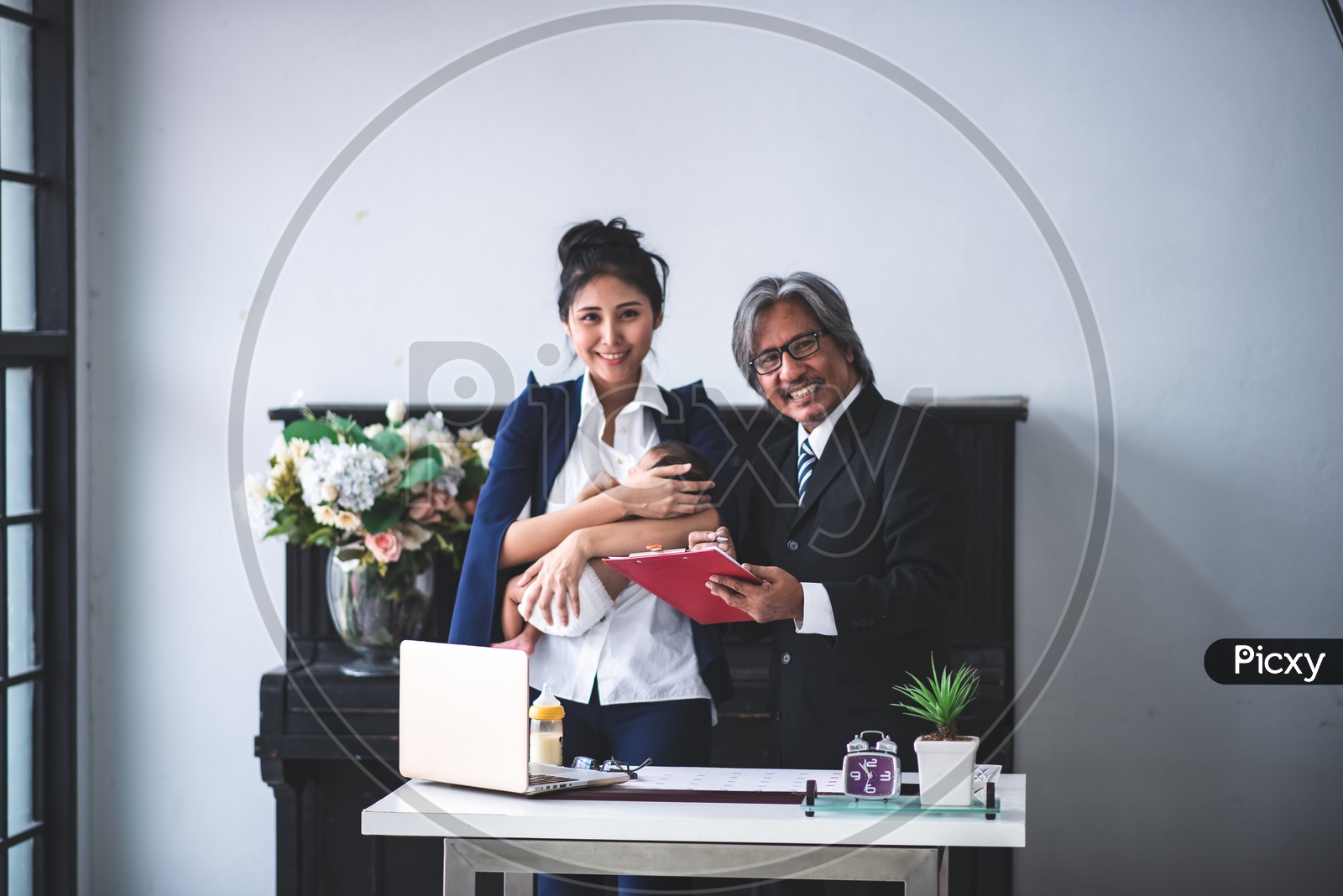 Young Asian Businesswoman Mother working at the office and taking care of her Baby