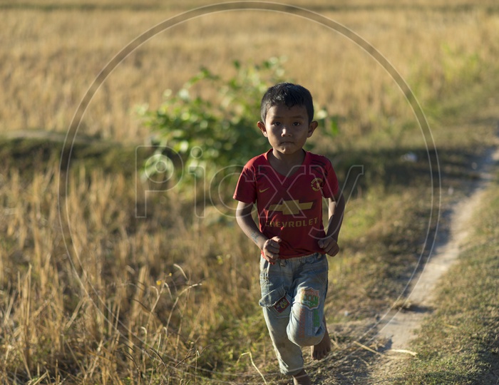 Young Boy Running At Agricultural Fields