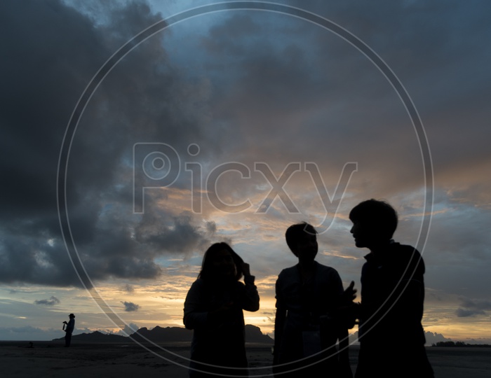 Silhouette Of Group Of People Over Sunset Sky