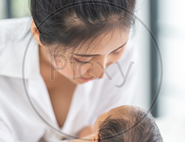 A young Asian mother holding a baby in her hands