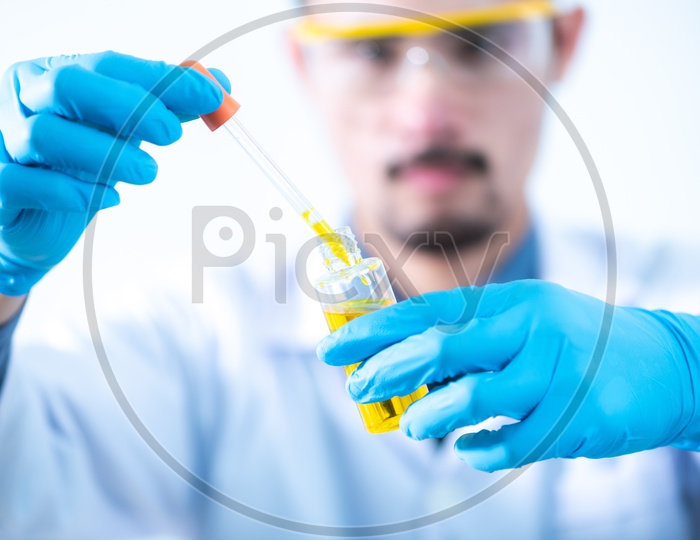 Asian Research Scientist Taking a Sample from Bio Fuel Solution in Test Tube at Laboratory