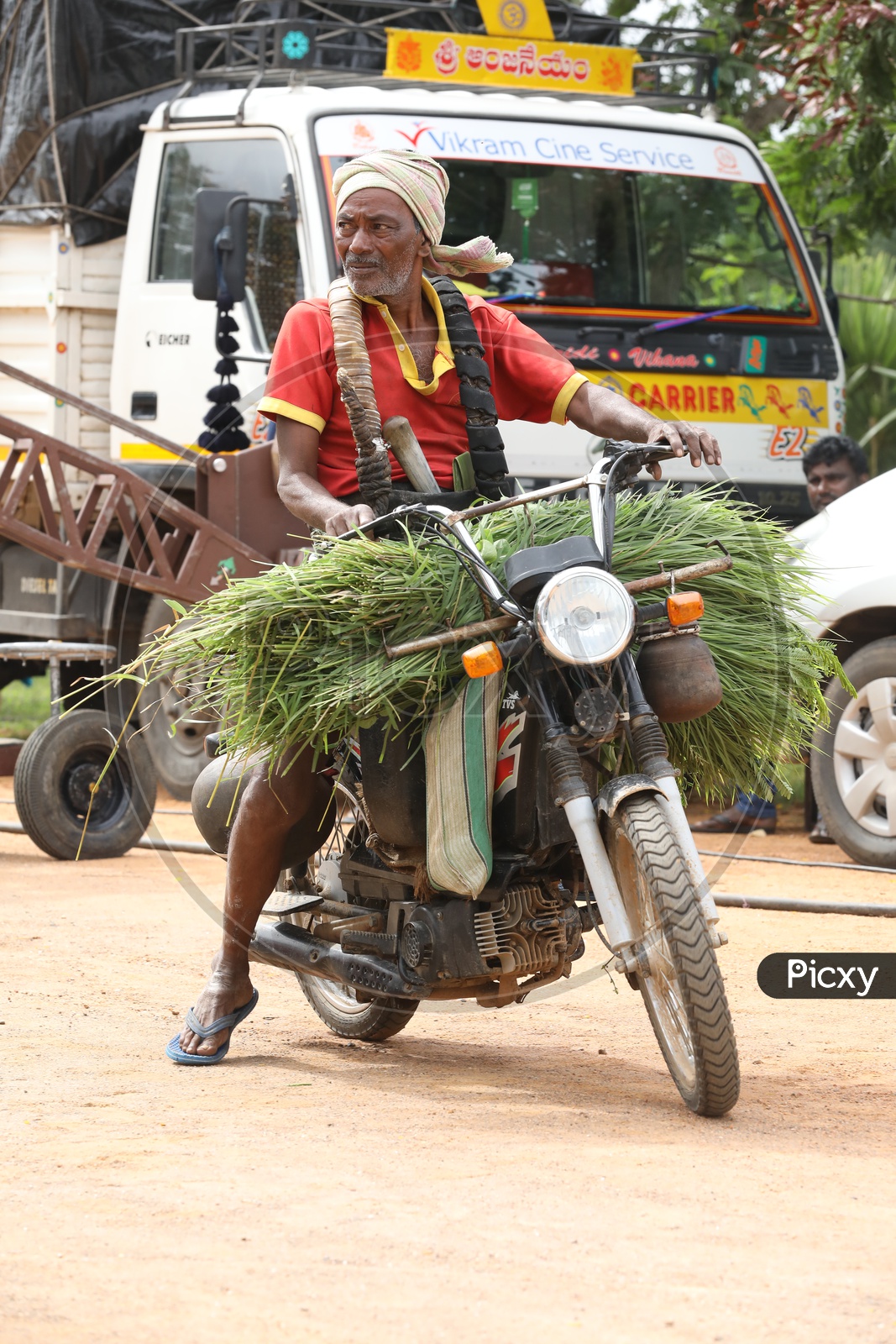 Palm Tree Climber riding a motorcycle with grass load 