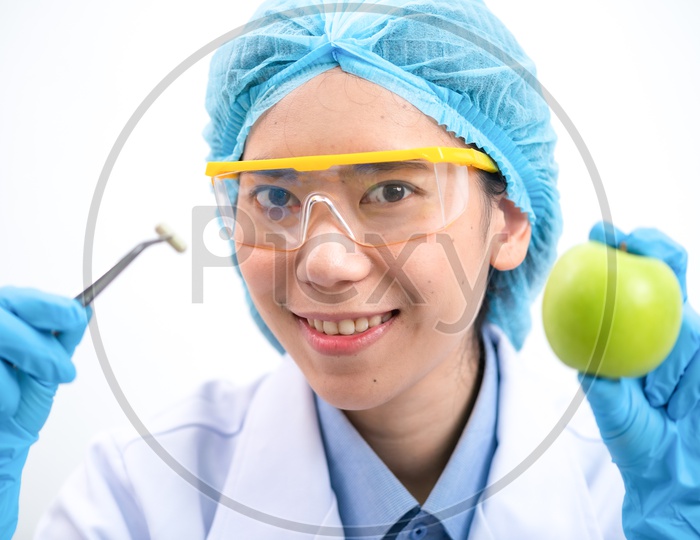Young Asian Female Scientist Holding Capsule and Apple in Hand at Laboratory