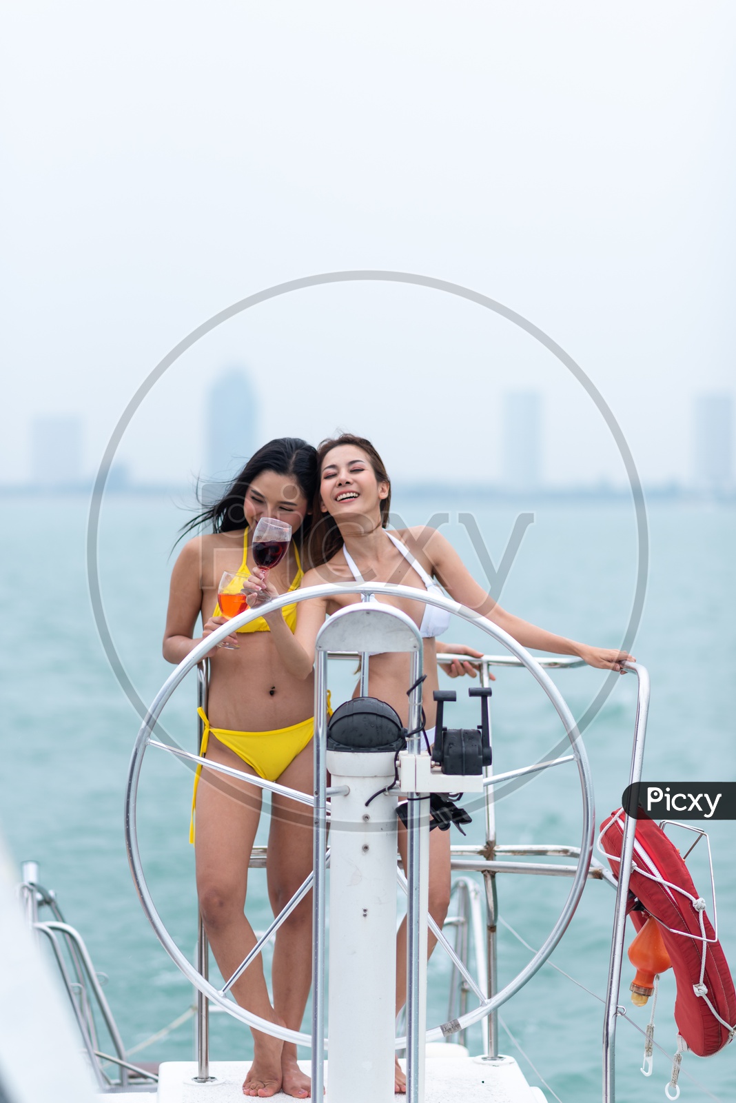 Young Asian Women in Bikini on a Yacht drinking Wine
