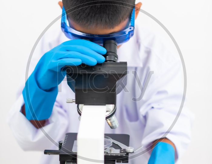 Asian Child Scientist Looking on Microscope at Laboratory