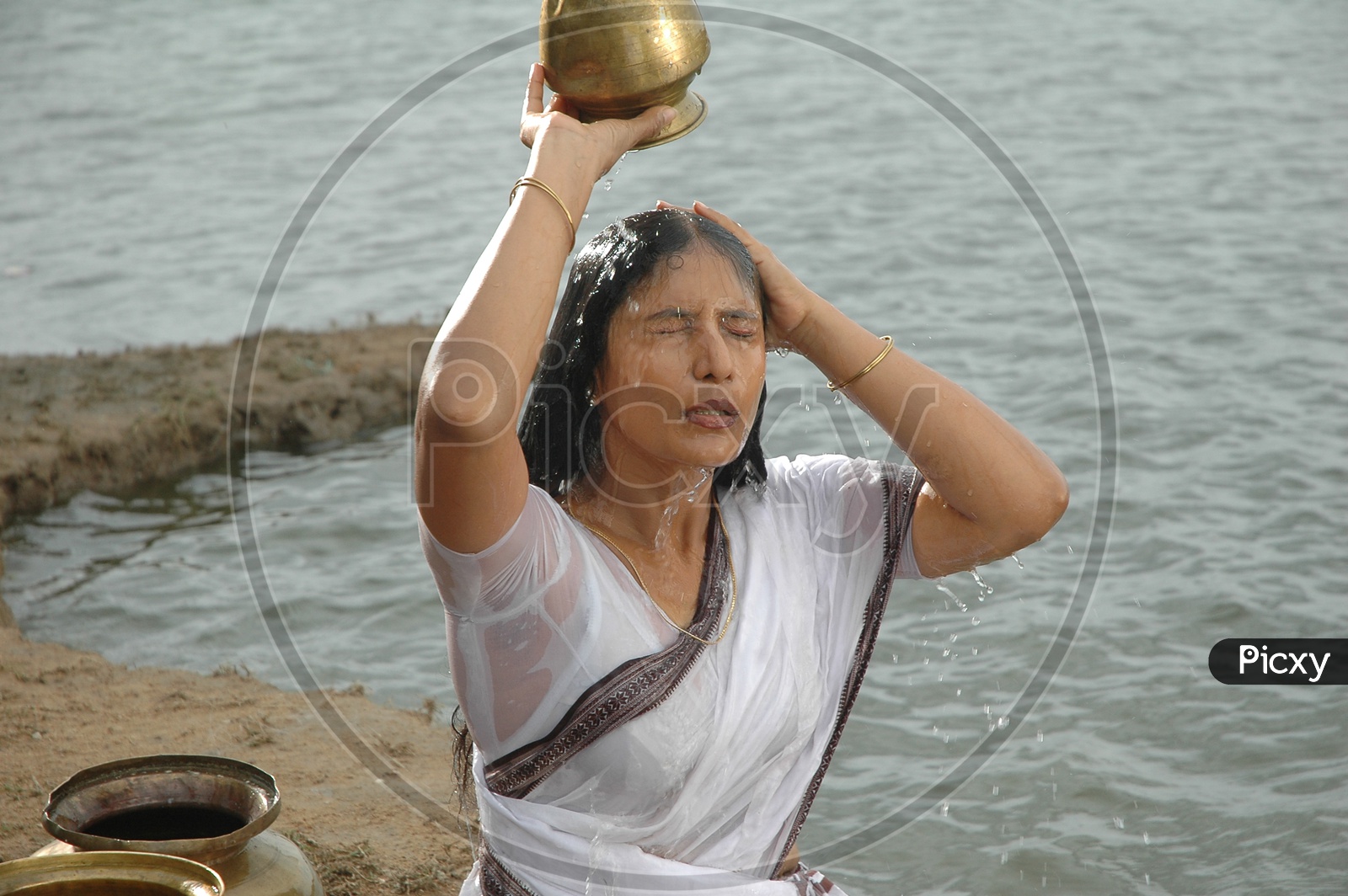 Image of Indian Widow Woman Pouring Water on HeadSB854989Picxy