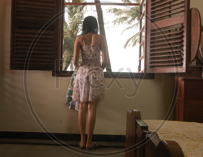 Indian Girl standing by the window after shower